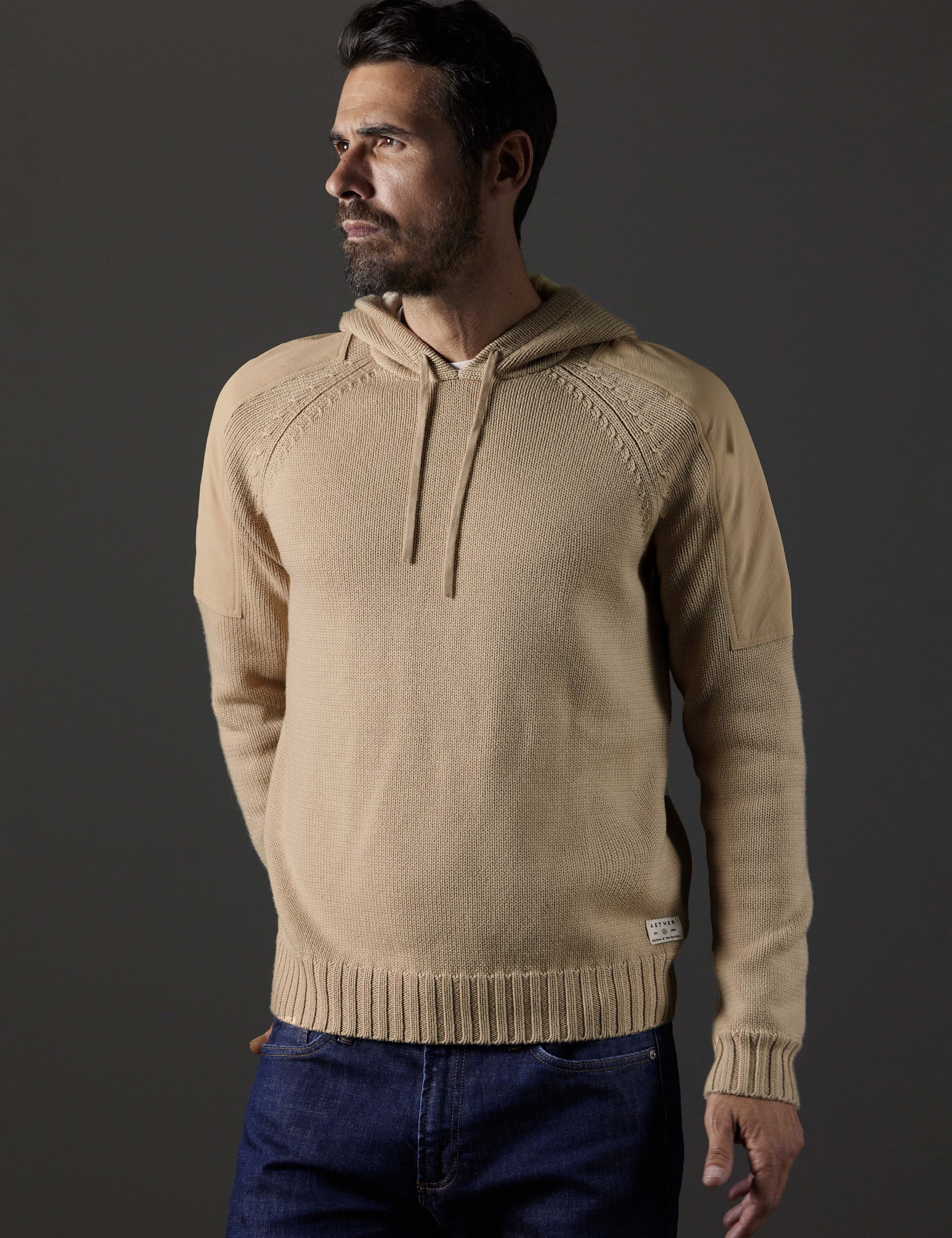 Front body view of man wearing Benson Hooded Sweater in Oatmeal beige from AETHER Apparel.