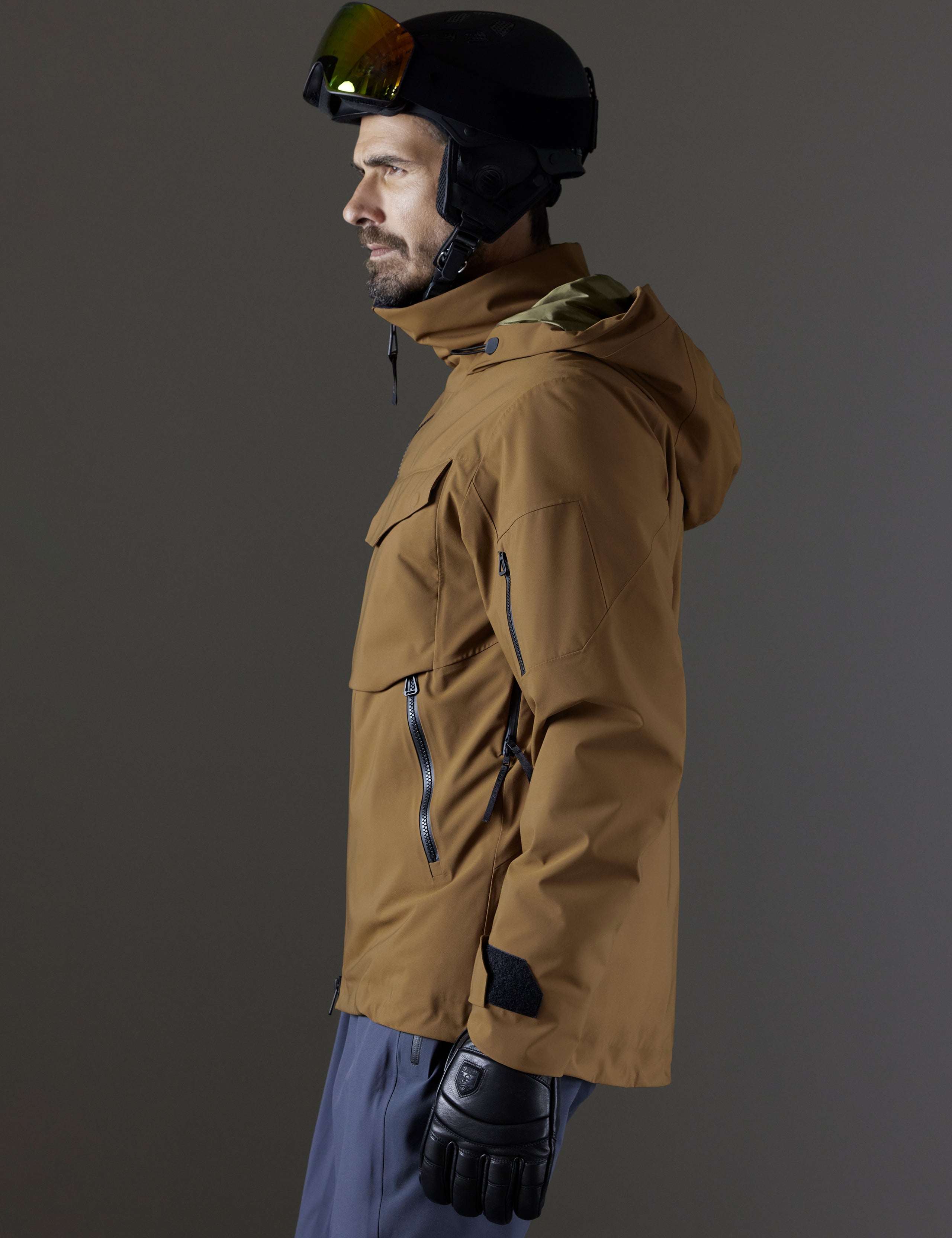 Side profile body view of man wearing Brighton Insulated Snow Jacket in Rubber Brown from AETHER Apparel.