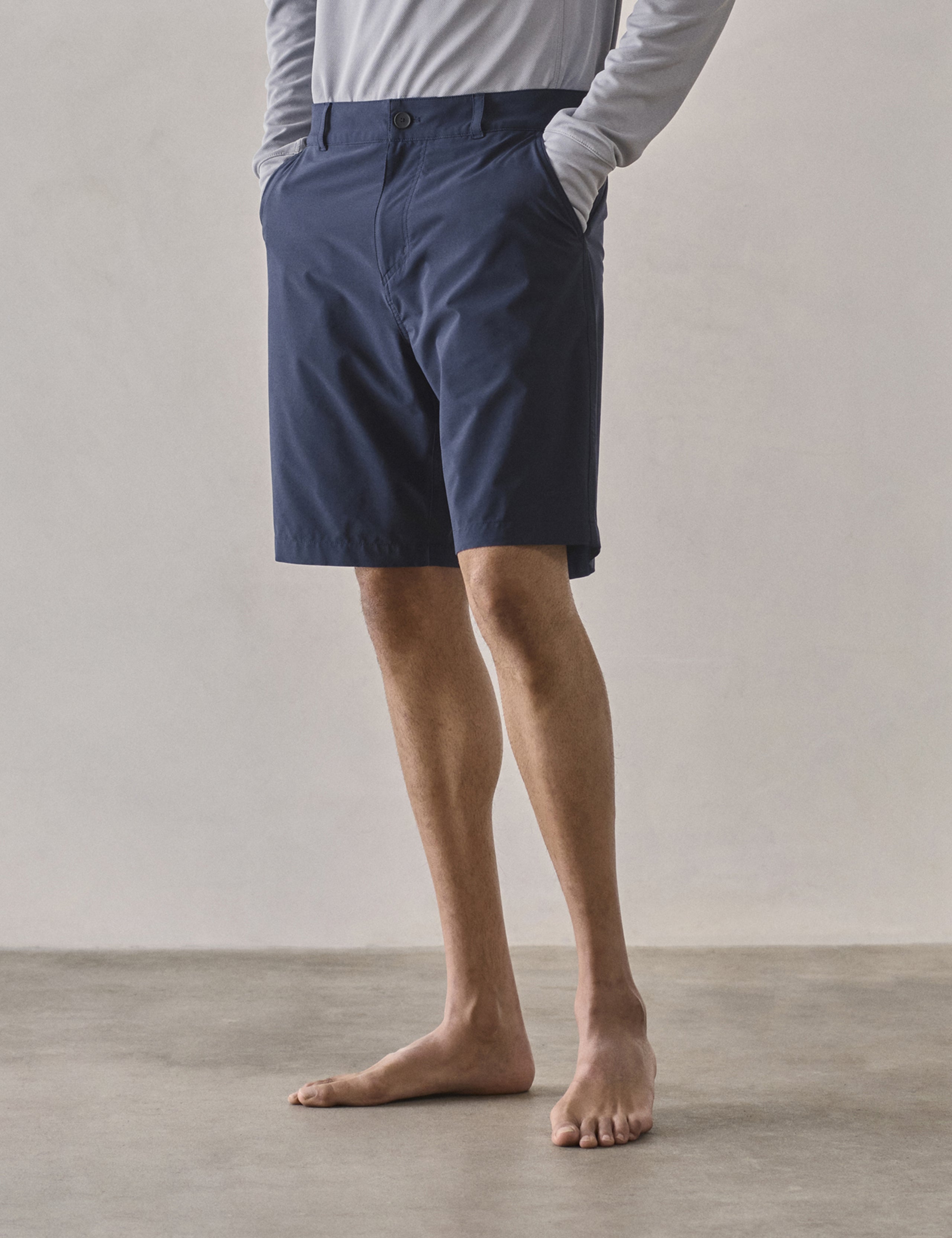 Front 3/4 lower-body view of man wearing Catalina Submersible Short in Total Eclipse dark blue from AETHER Apparel.