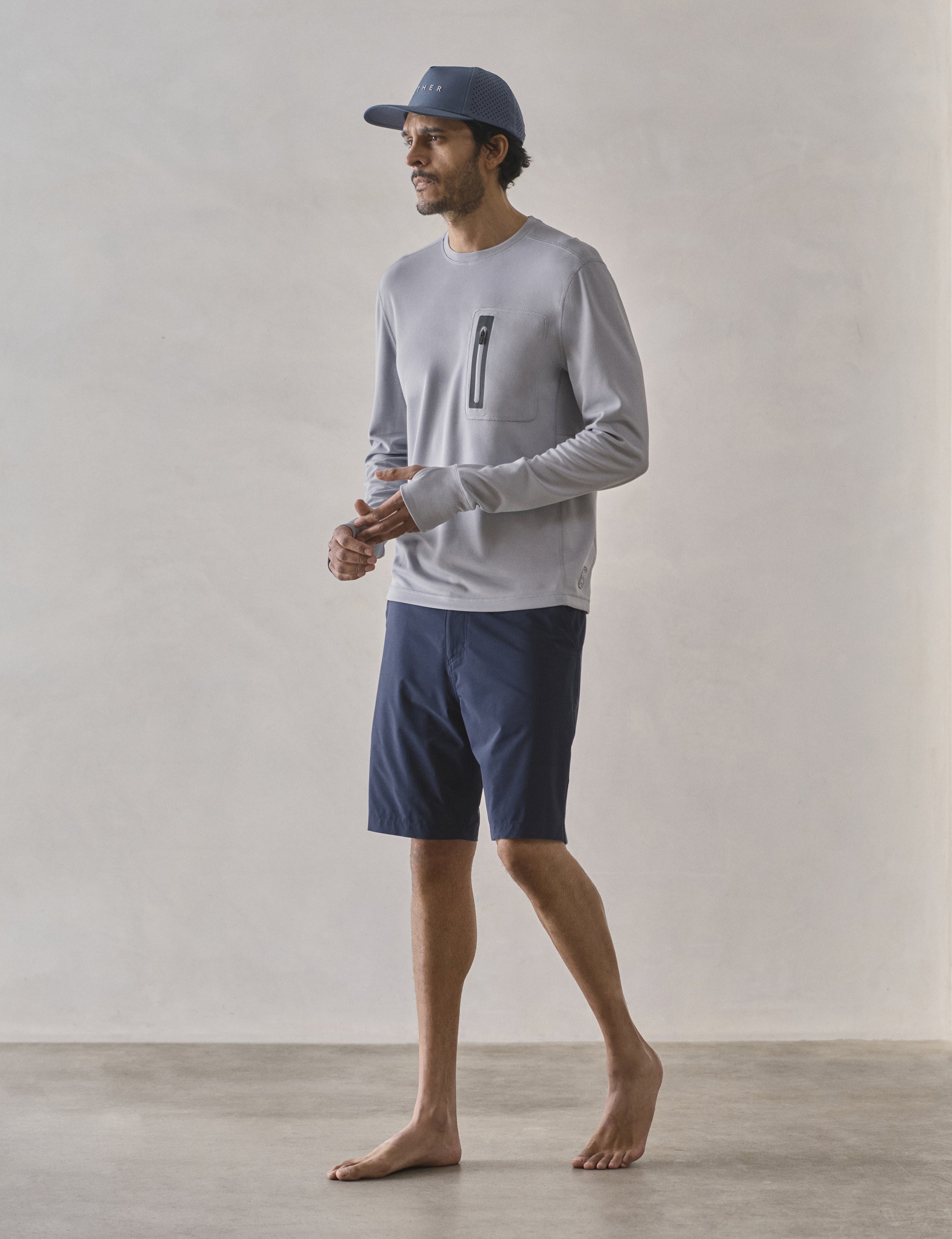 Front 3/4 full-body view of man wearing Catalina Submersible Short in Total Eclipse dark blue from AETHER Apparel.