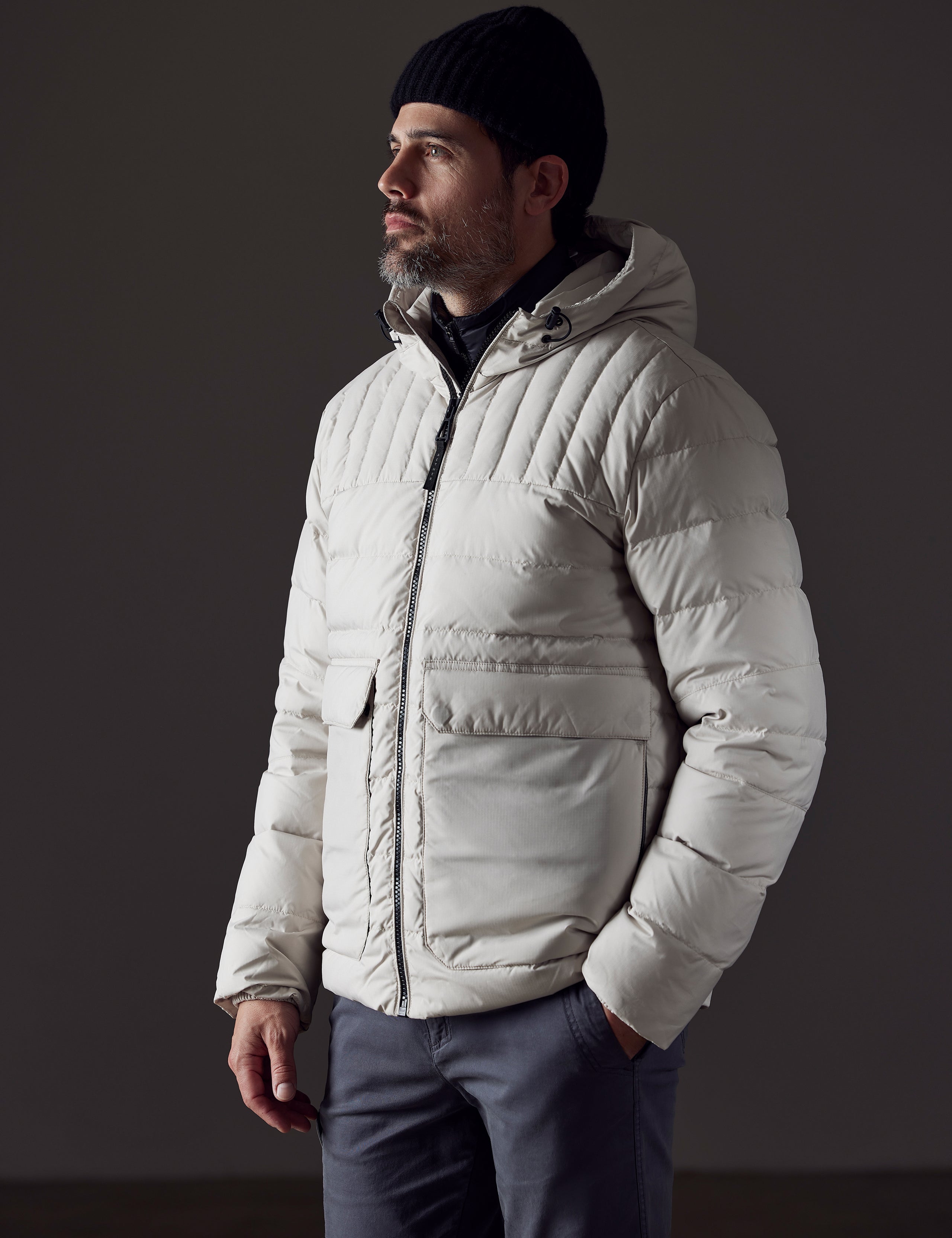 Front 3/4 body view of man wearing Hudson Down Jacket in Bone White from AETHER Apparel.
