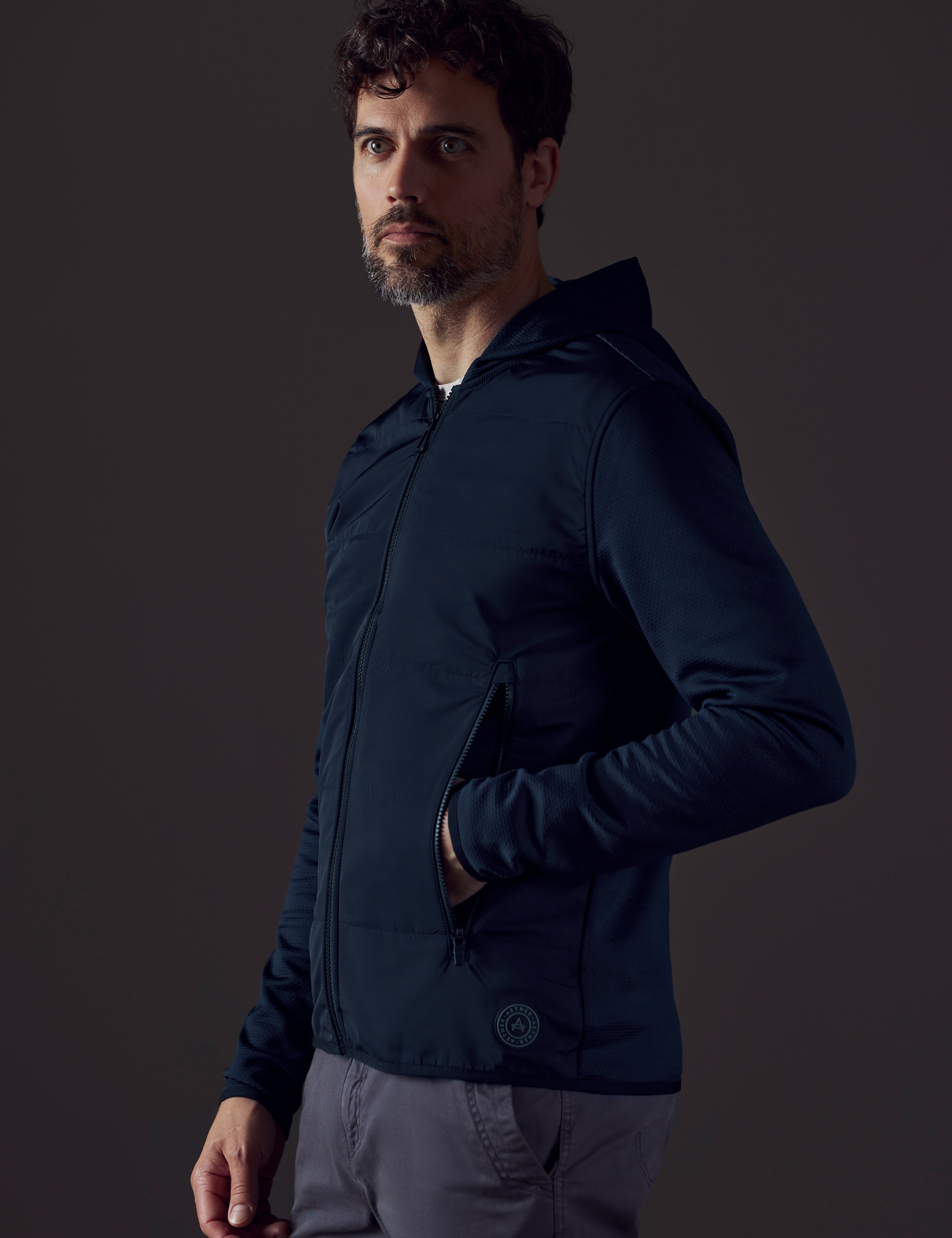 Front 3/4 body view of man wearing Morgan Technical Hoodie in Total Eclipse dark blue from AETHER Apparel.