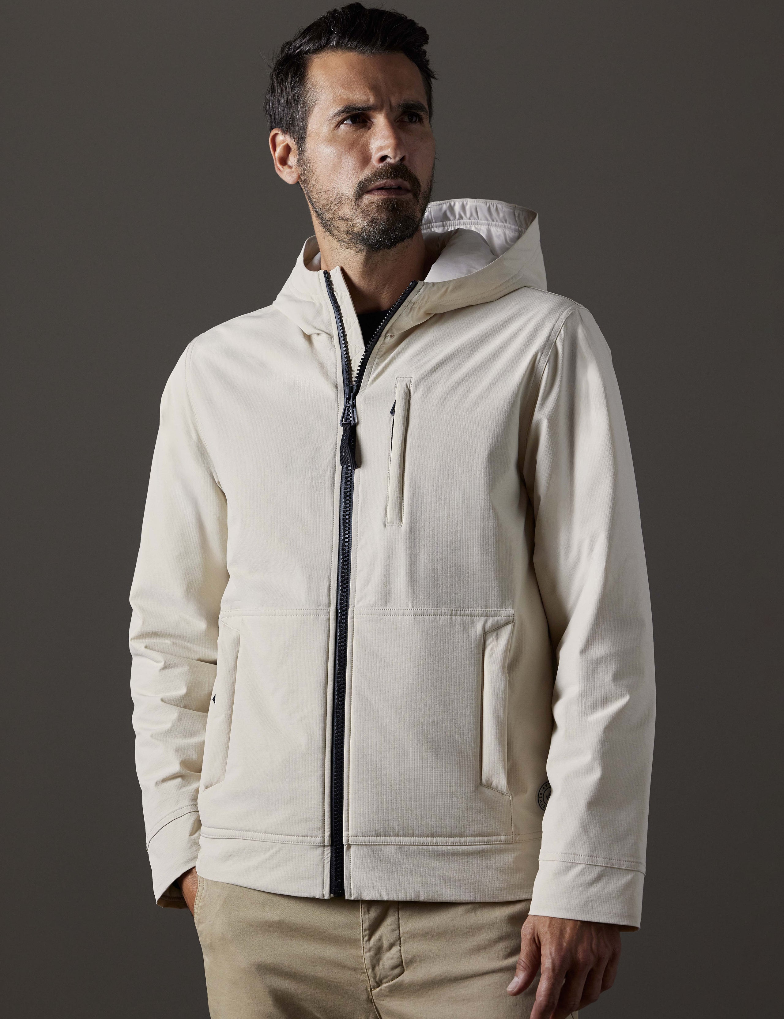 Front body view of man wearing Stornaway Insulated Hoodie in Bone white from AETHER Apparel.