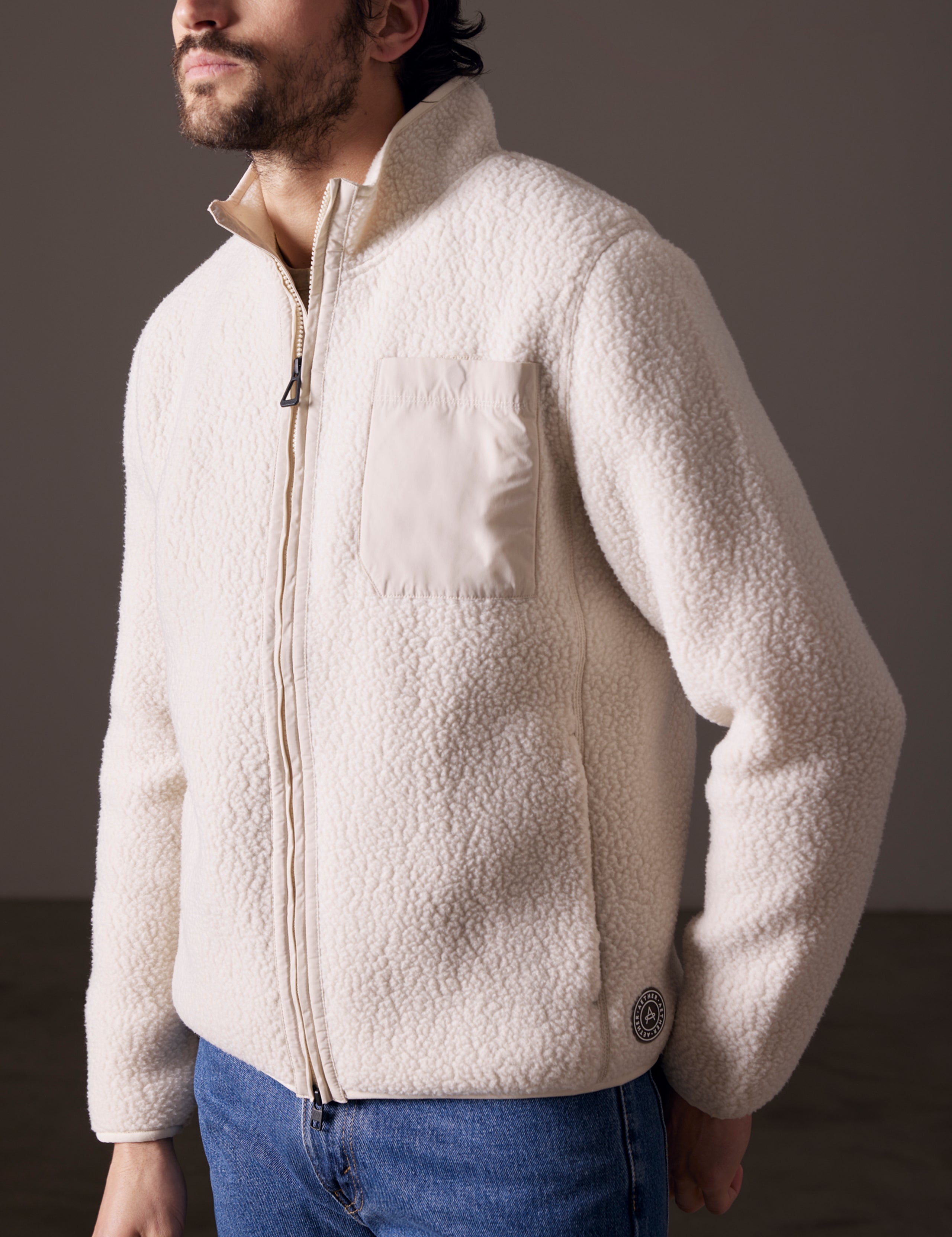 Front 3/4 body view of man wearing Walsh Full-Zip in Bone white from AETHER Apparel.