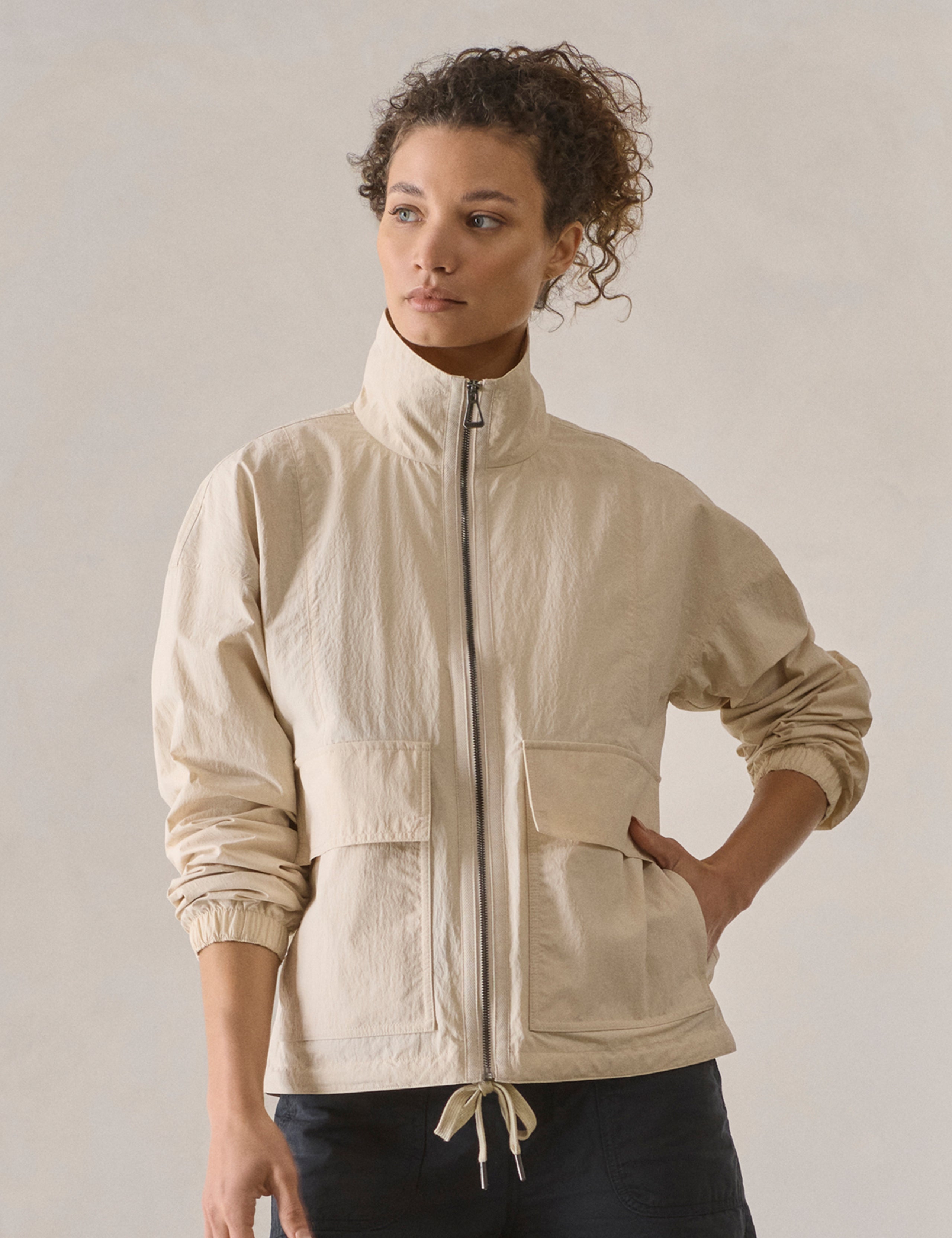 Front view of woman wearing Mila Windbreaker in Bone white from AETHER Apparel.