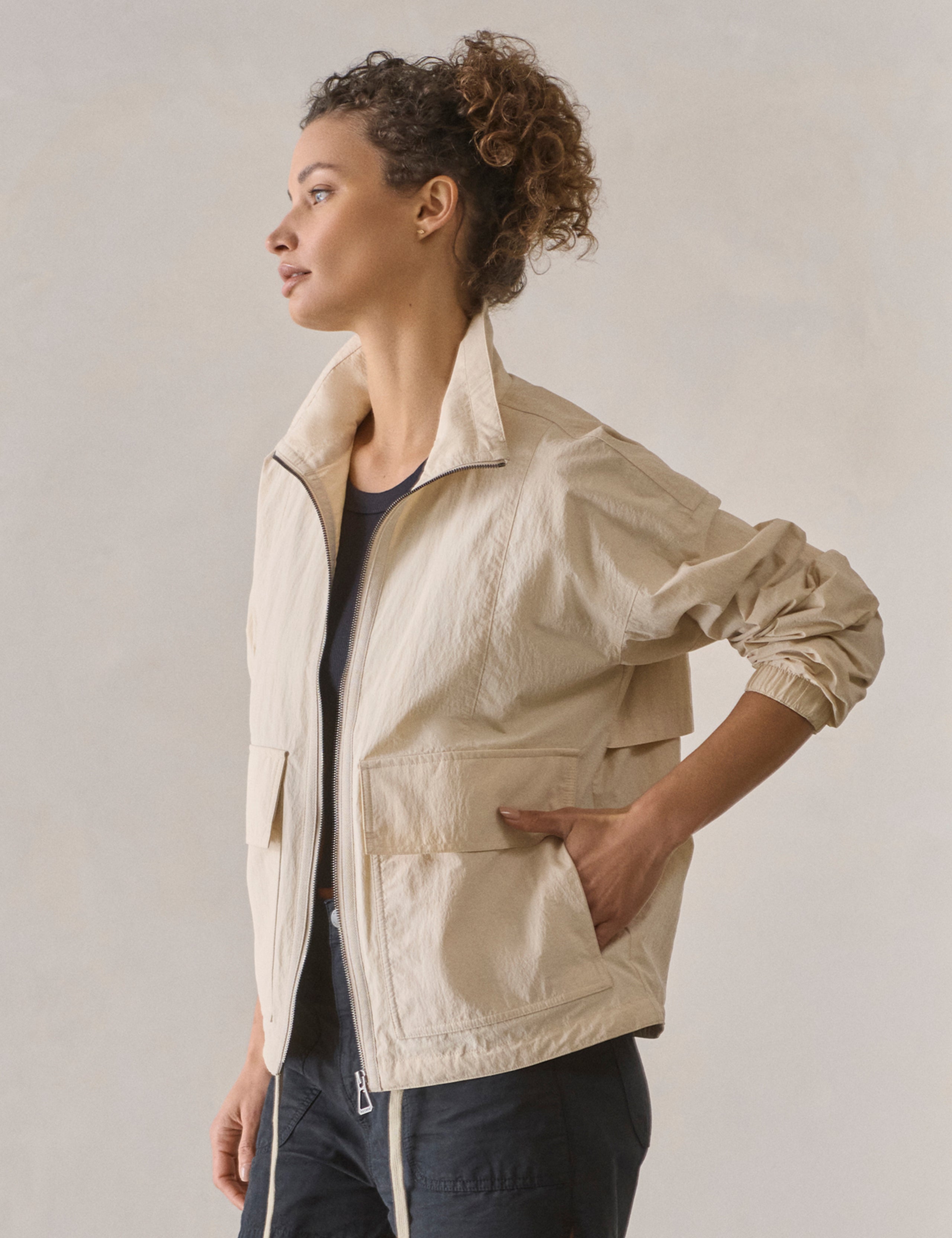 Front 3/4 body view of woman wearing Mila Windbreaker in Bone white from AETHER Apparel.