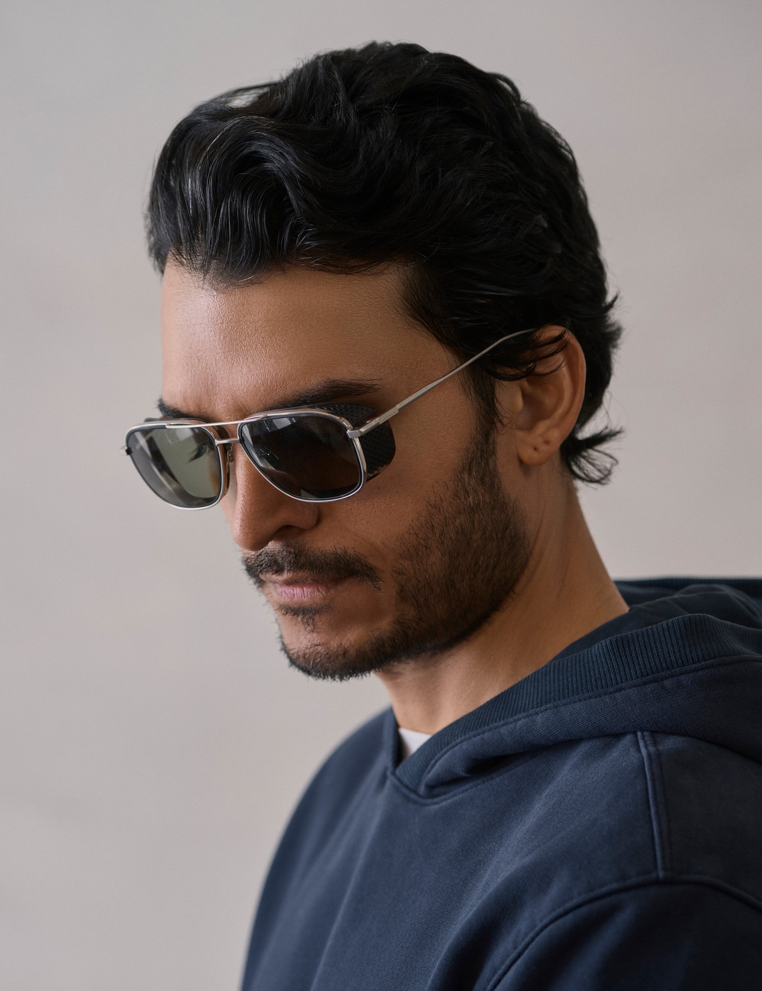 Front 3/4 view of man wearing Summit Sunglass in Brushed Silver titanium with Grey Lens from AETHER Apparel.