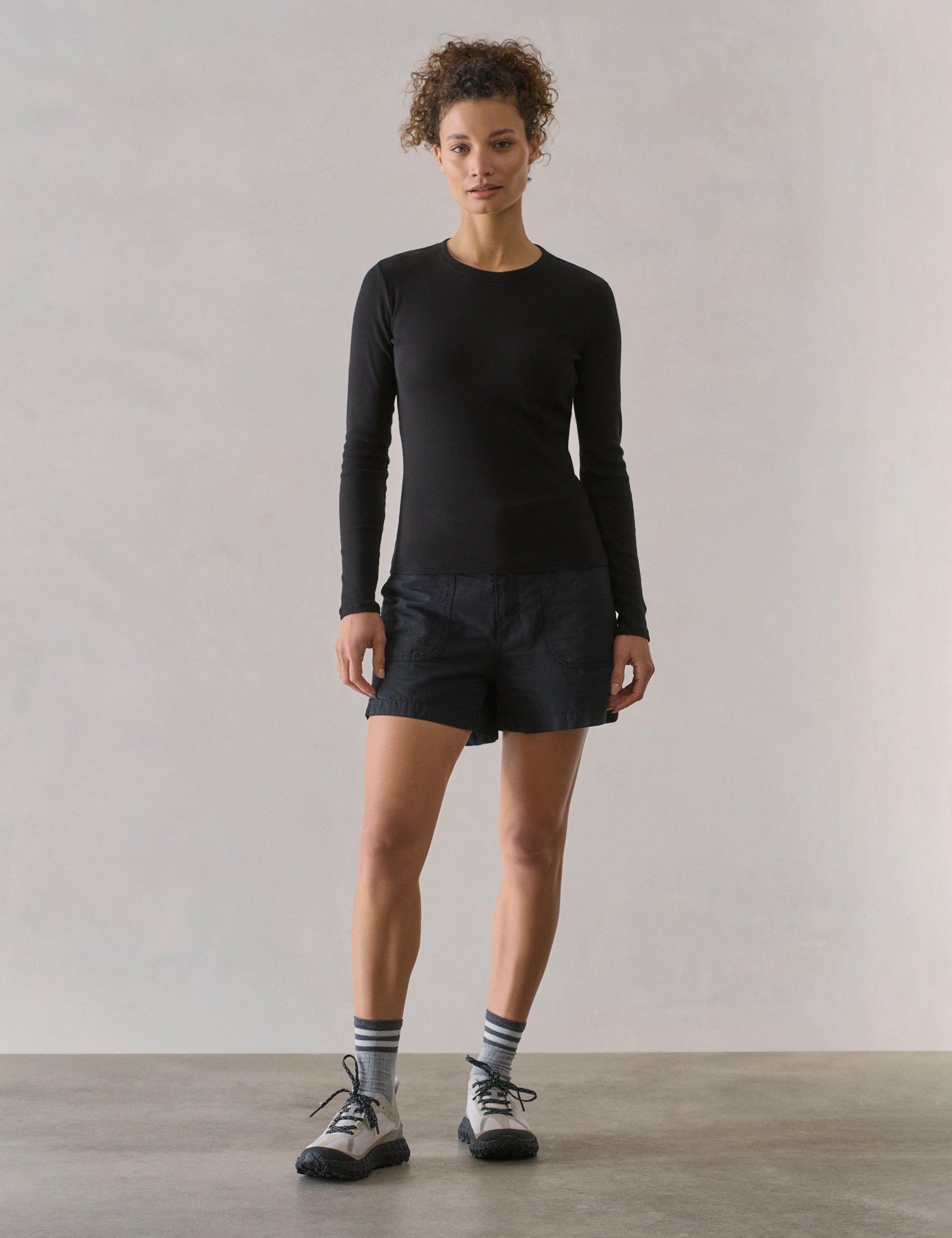 Front full body view of woman wearing Masai Safari Short in Onyx Black from AETHER Apparel.