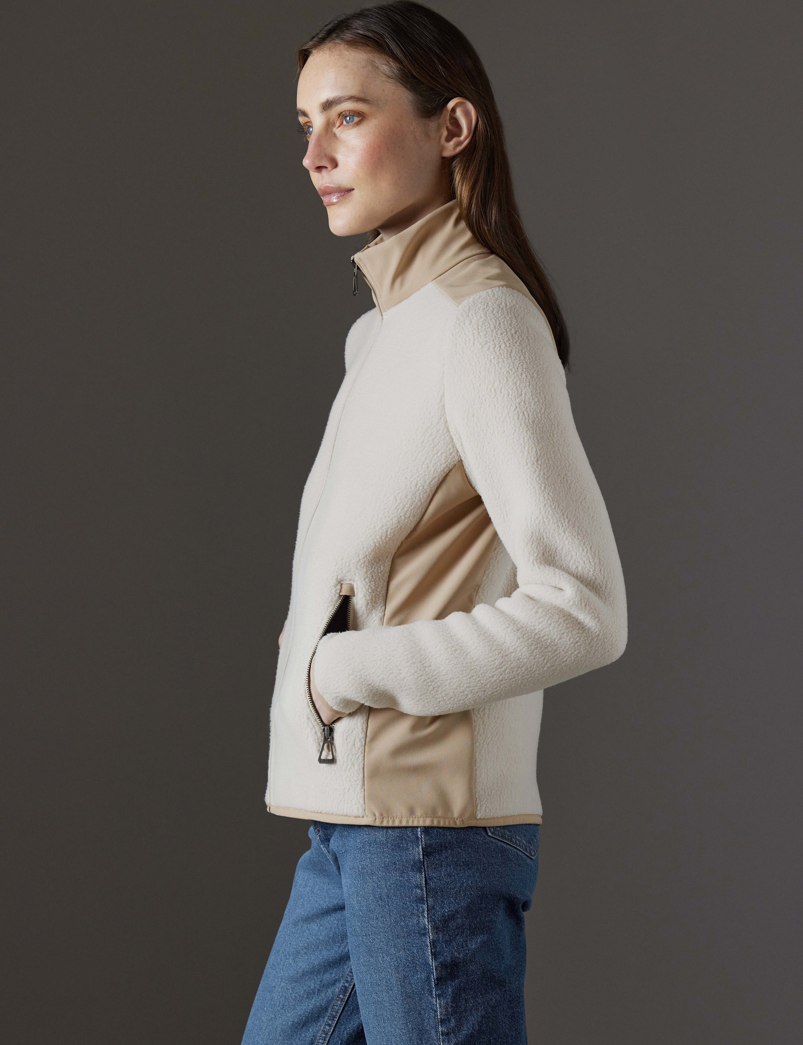 Side profile body view of woman wearing Walsh Full-Zip 2.0 in Bone and Desert Tan from AETHER Apparel.